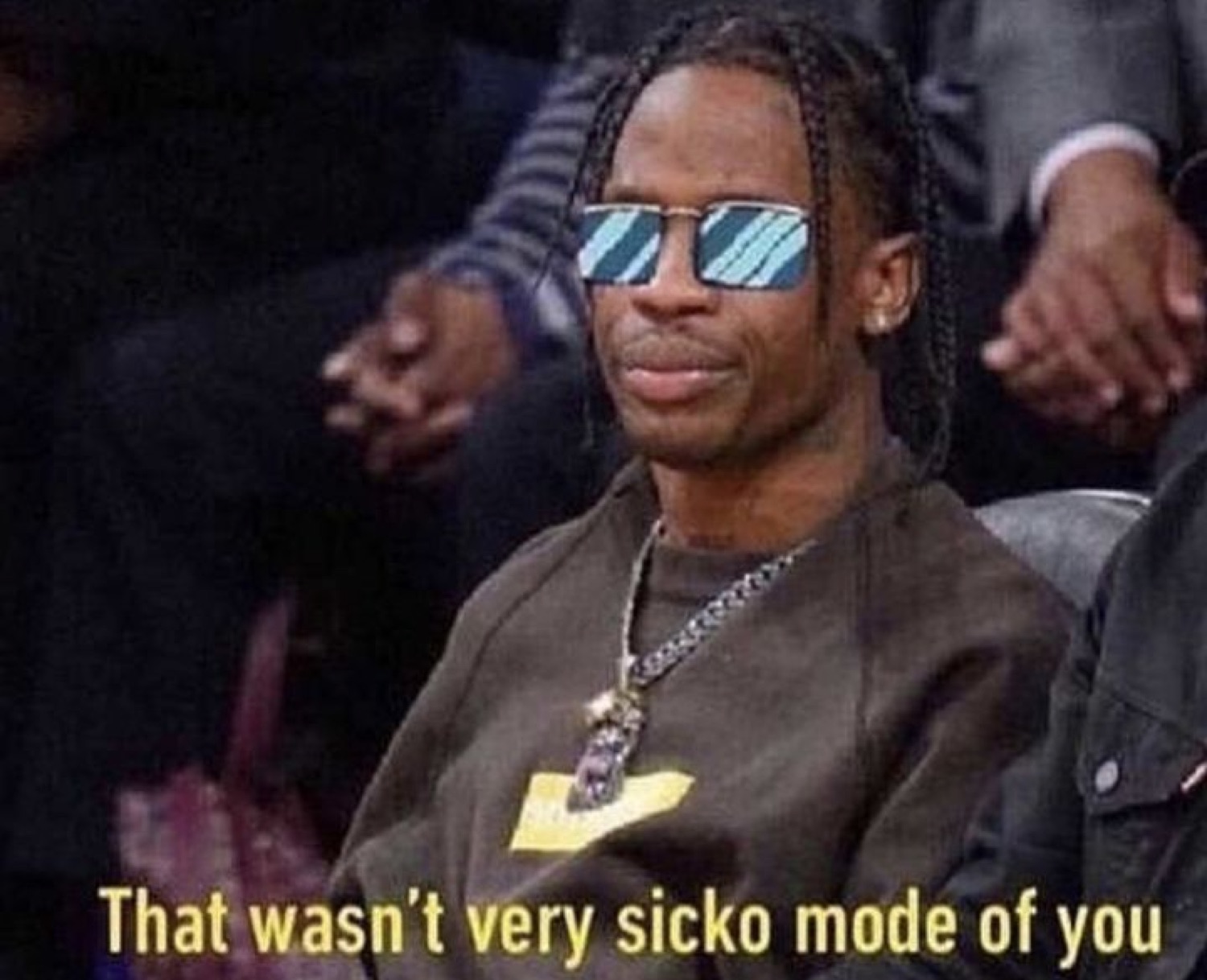 Man in blue-tinted sunglasses sitting courtside deadpan, captioned 'That wasn't very sicko mode of you'