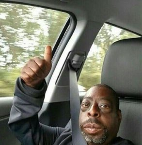 Man in a car giving a big thumbs up