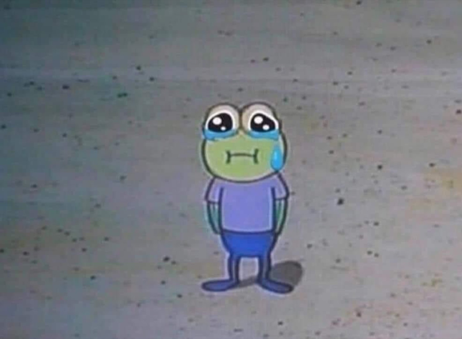 Little cartoon frog standing alone on the pavement with a fat tear rolling down