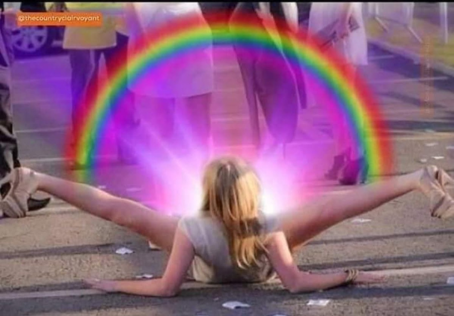 Woman collapsed in the splits on the street with a rainbow beaming out behind her