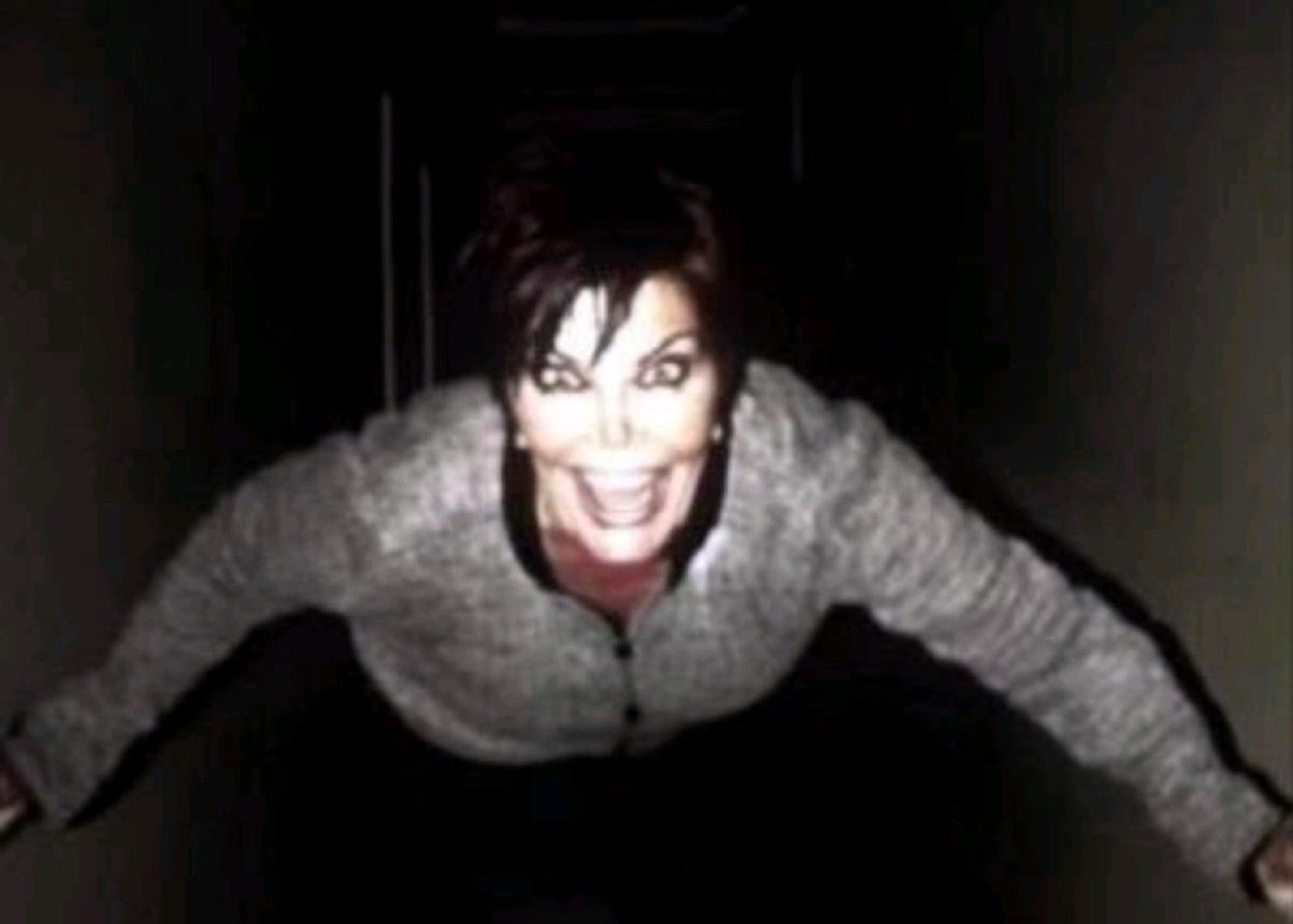 Kris Jenner crawling toward the camera in a dark hallway like a horror movie