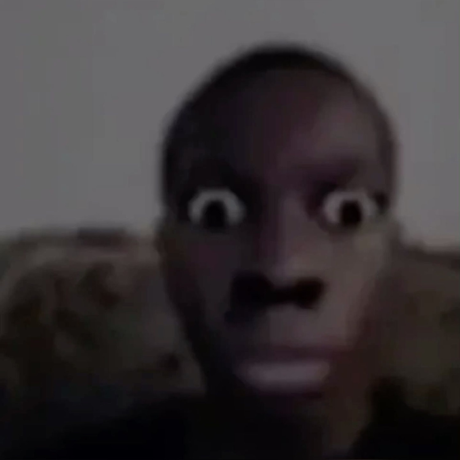 Guy on a couch in the dark with eyes bugging completely out of his head