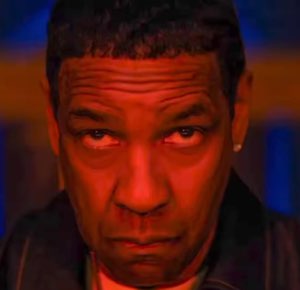 Denzel Washington bathed in red light, glaring down with a heavy, unimpressed stare