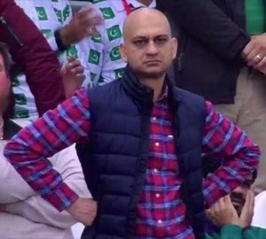 Bald man at a sports event with hands on hips, radiating pure disapproval