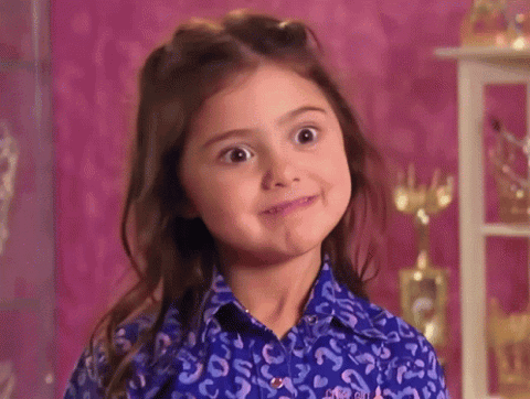 Little girl grinning with a mischievous smile