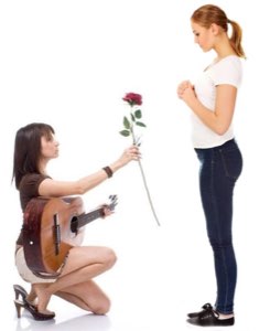 Woman kneeling with a guitar holding out a rose to another woman on a white background