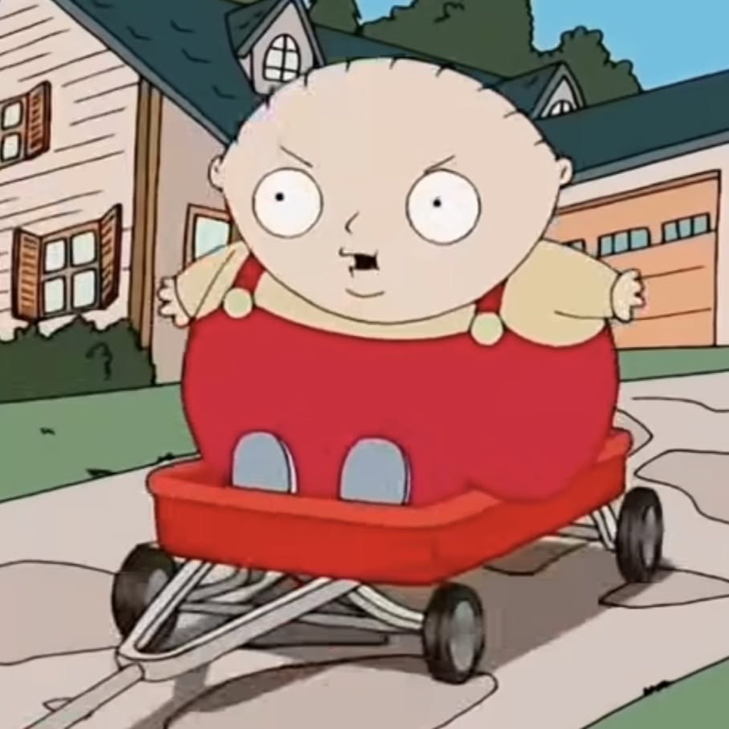 Stewie Griffin sitting in a red wagon with narrowed, suspicious eyes