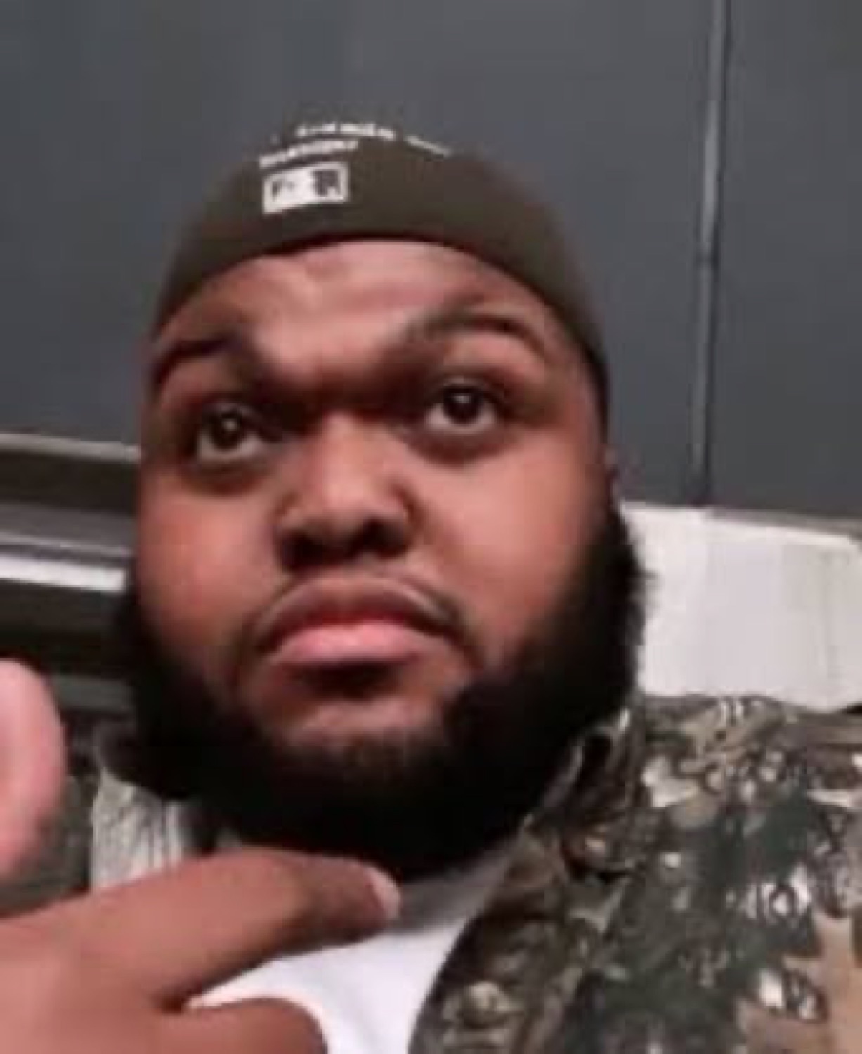 Bearded man in a beanie raising an eyebrow with a suspicious stare