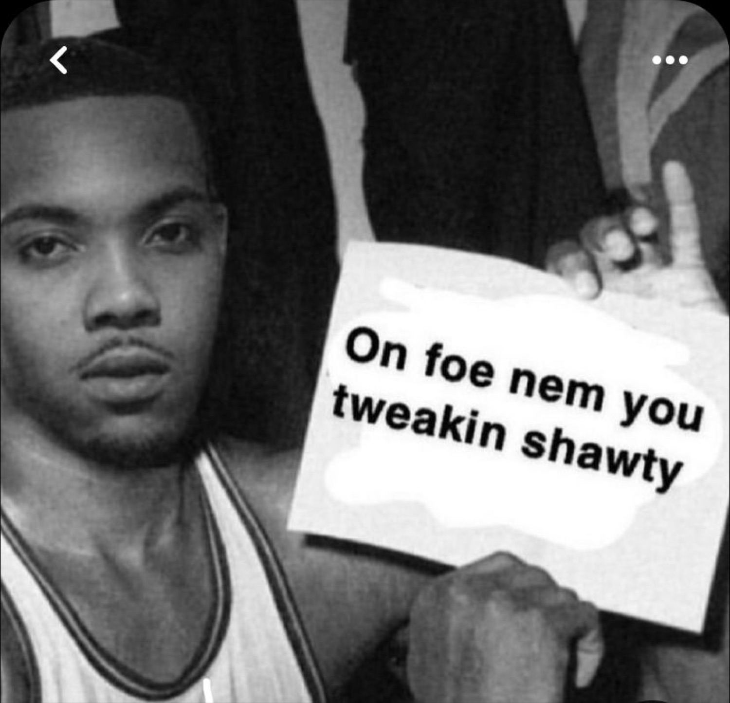 Deadpan man holding a sign reading 'On foe nem you tweakin shawty'