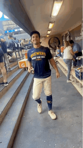 Sal Frelick in a Brewers shirt walking down a hallway giving a thumbs up