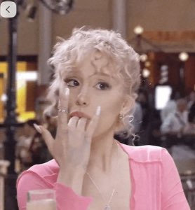 Woman in pink glancing sideways while biting her nail nervously