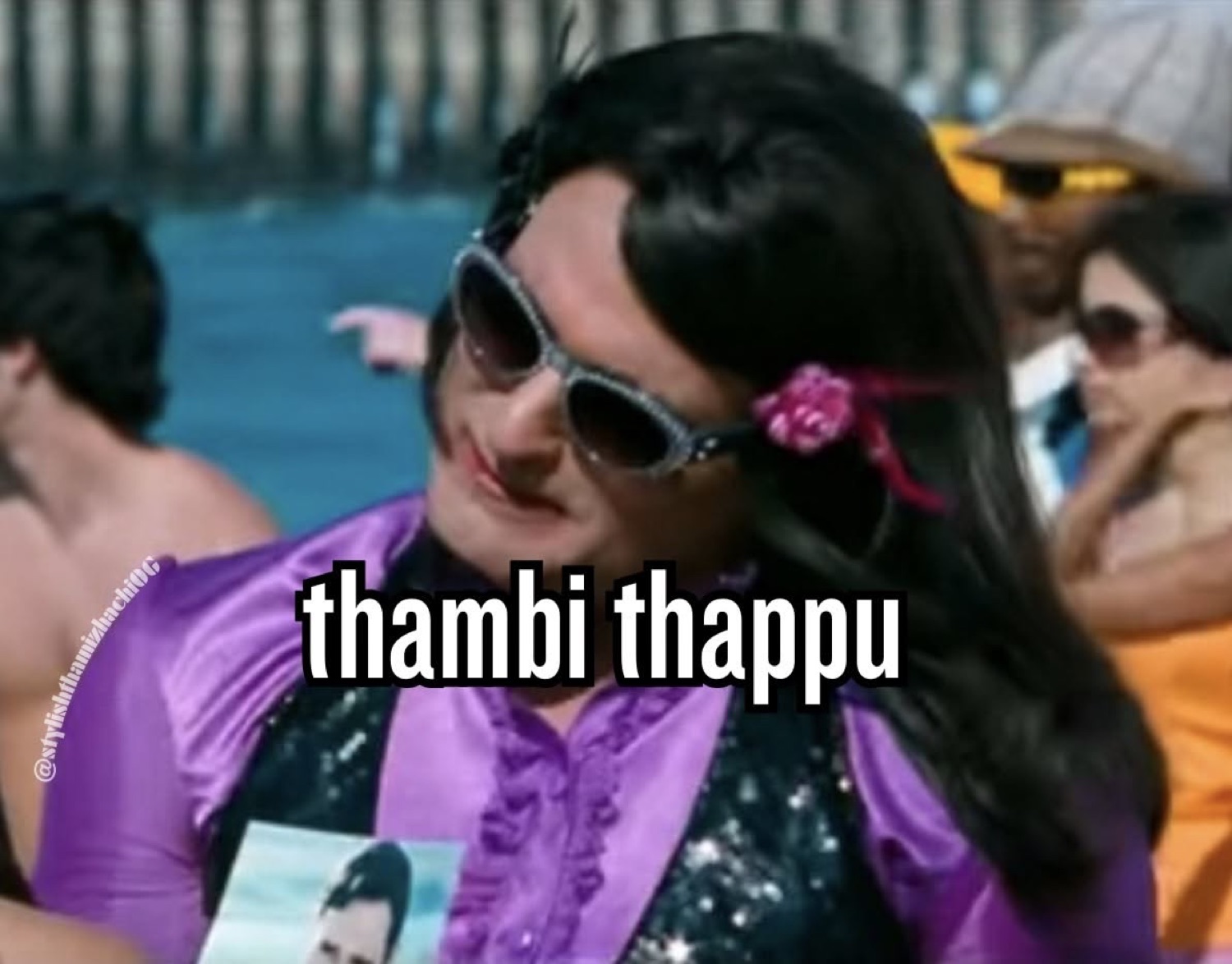 Man in a wig and sunglasses at a pool party, captioned 'thambi thappu'