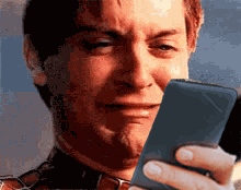 Tobey Maguire as Peter Parker crying while looking at his phone