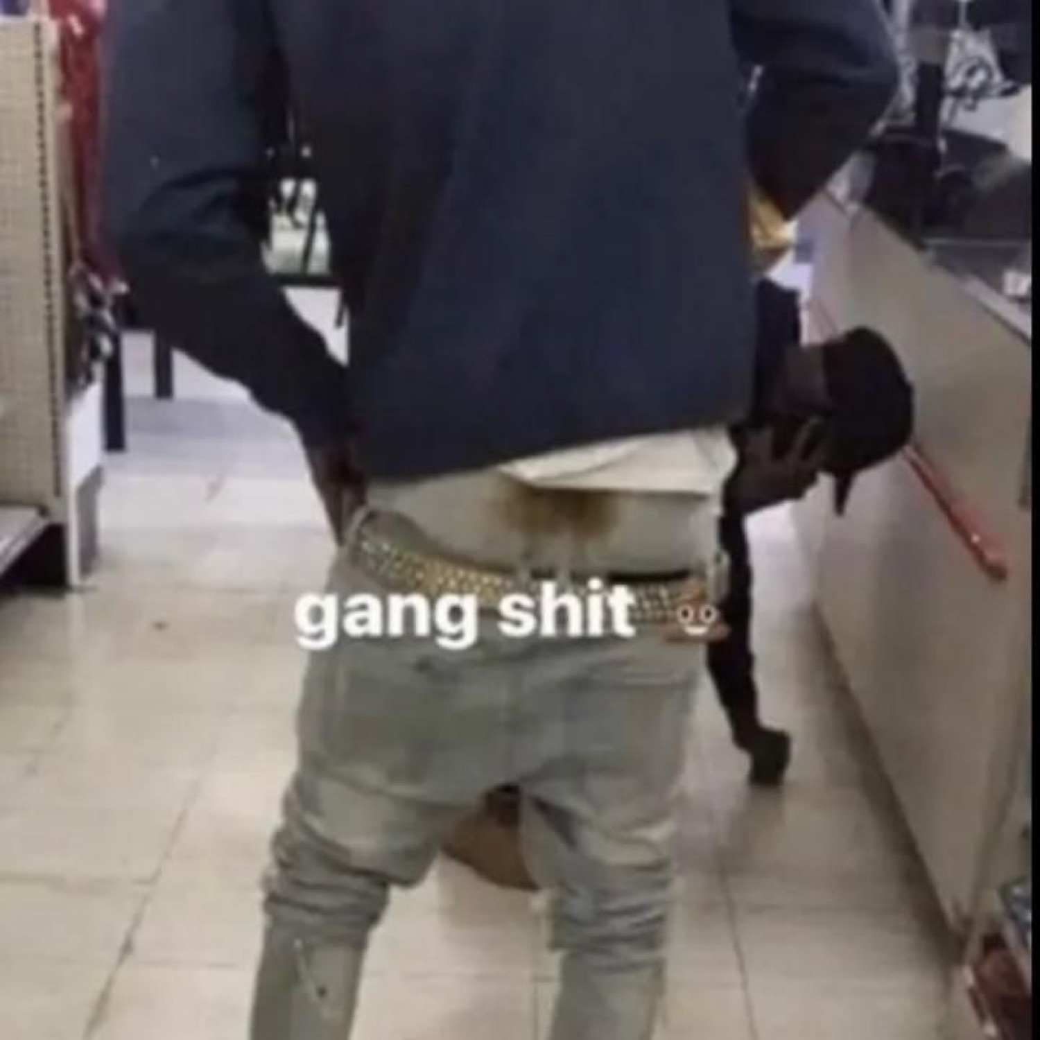 Person from behind with low-slung jeans and a studded belt, captioned 'gang shit'
