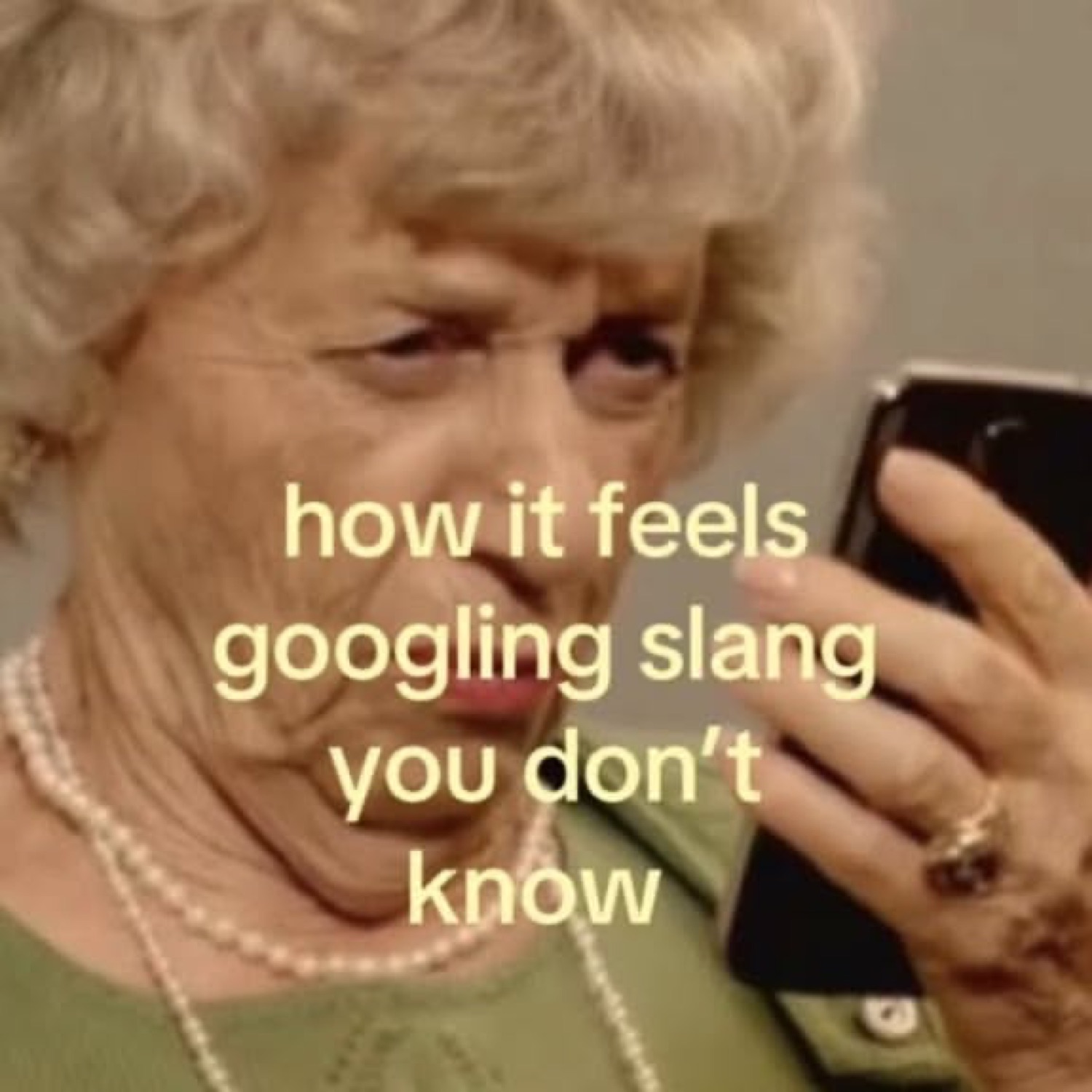 Older woman squinting at her phone in confusion under 'how it feels googling slang you don't know'
