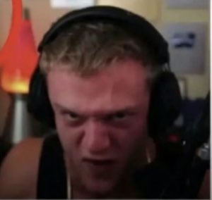 Gamer in headphones scrunching up his face and yelling in pure rage