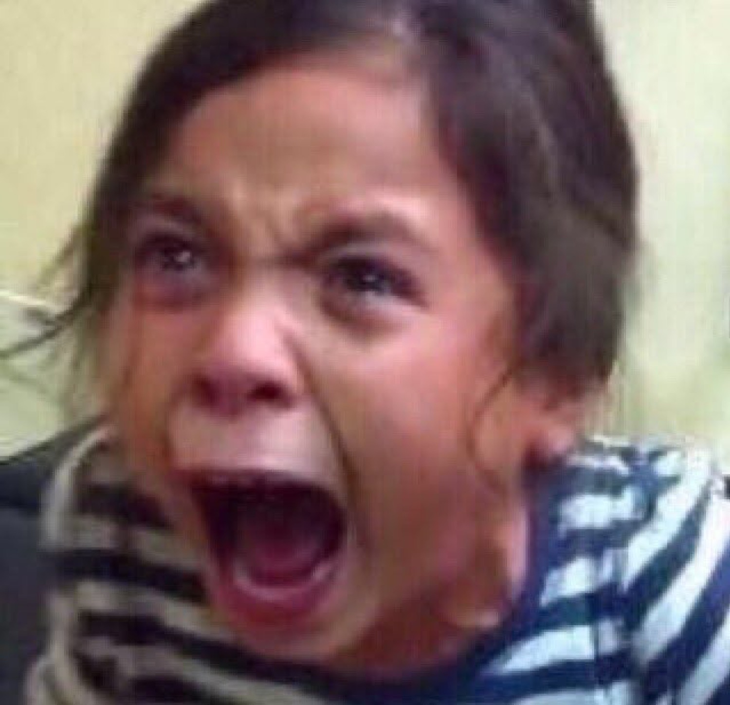 Little girl screaming at full volume with eyes wide and mouth completely open
