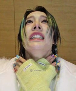 Green-streaked hair, sweater paws up, face crumpled mid-sob