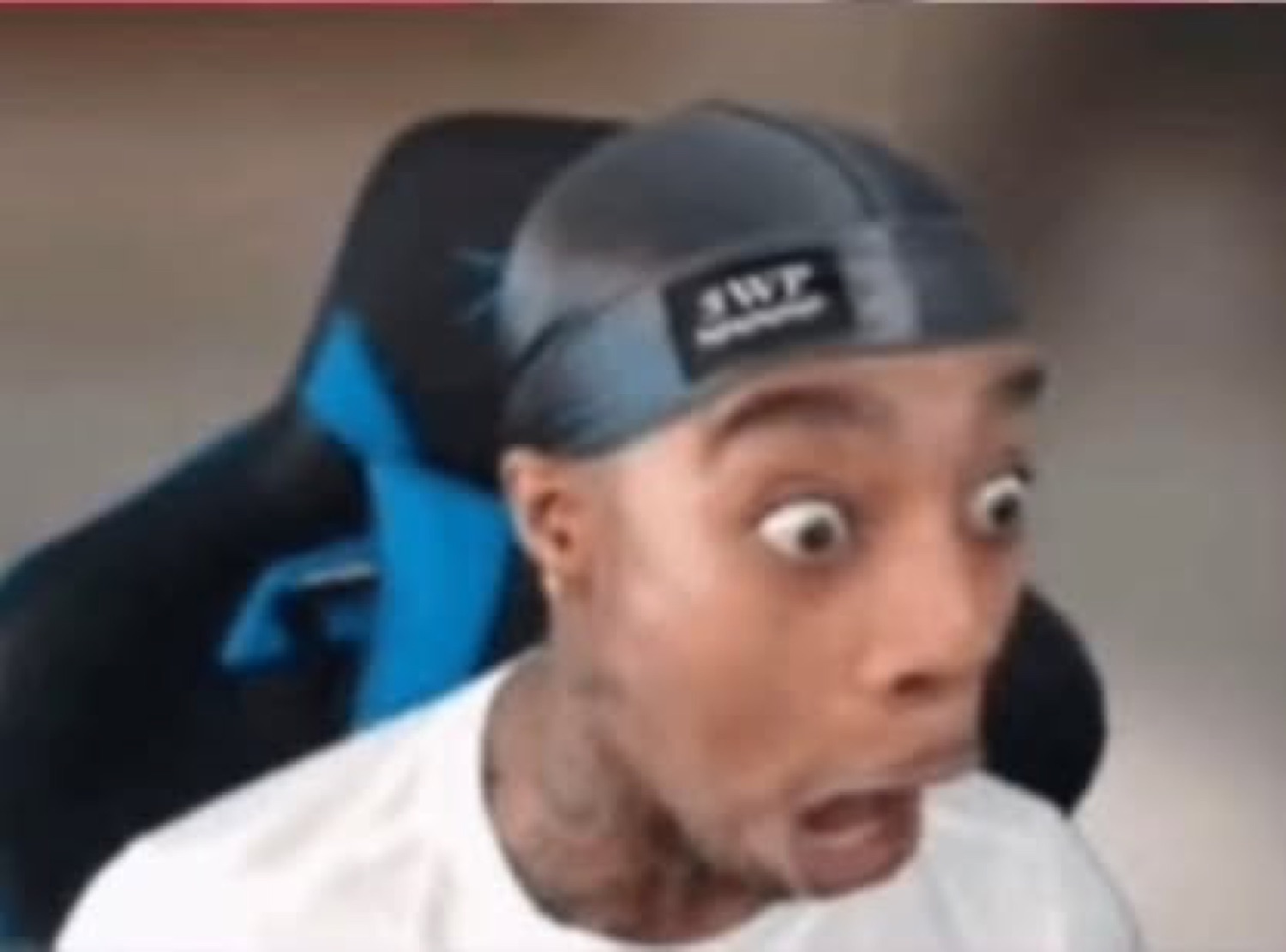 Guy in a durag leaning back in a gaming chair, eyes popped and jaw dropped
