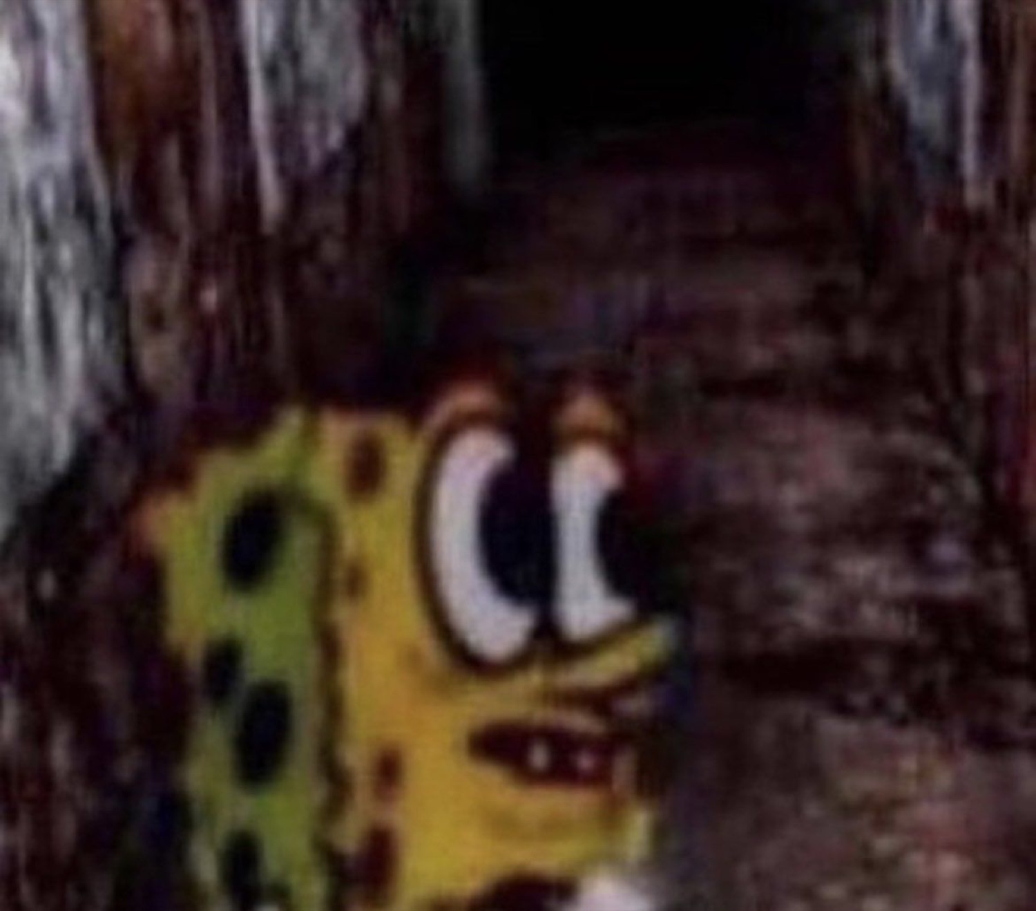 Grainy dark shot of SpongeBob peeking around a corner looking terrified