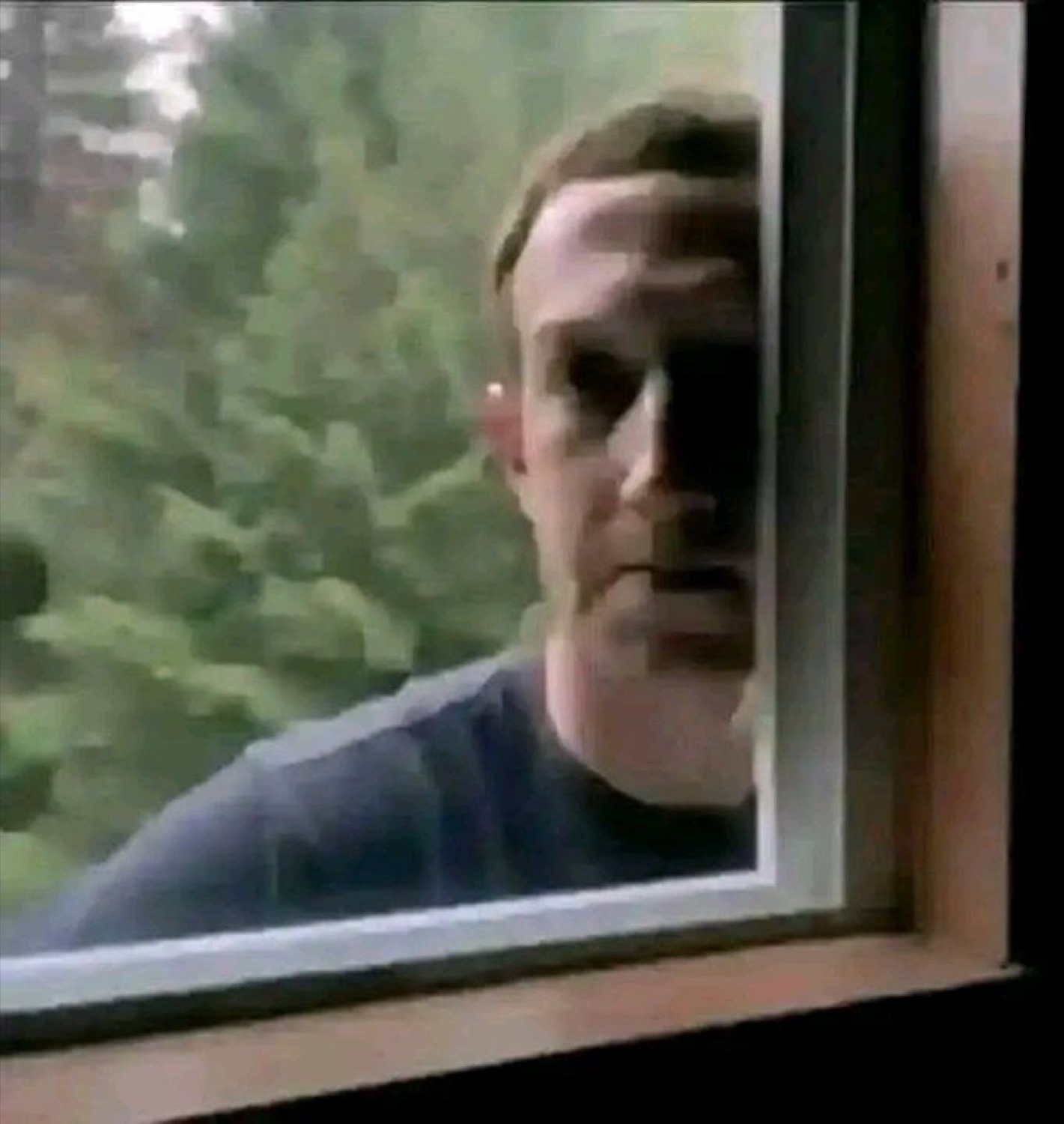 Mark Zuckerberg peering through a window with a blank, unsettling stare from outside