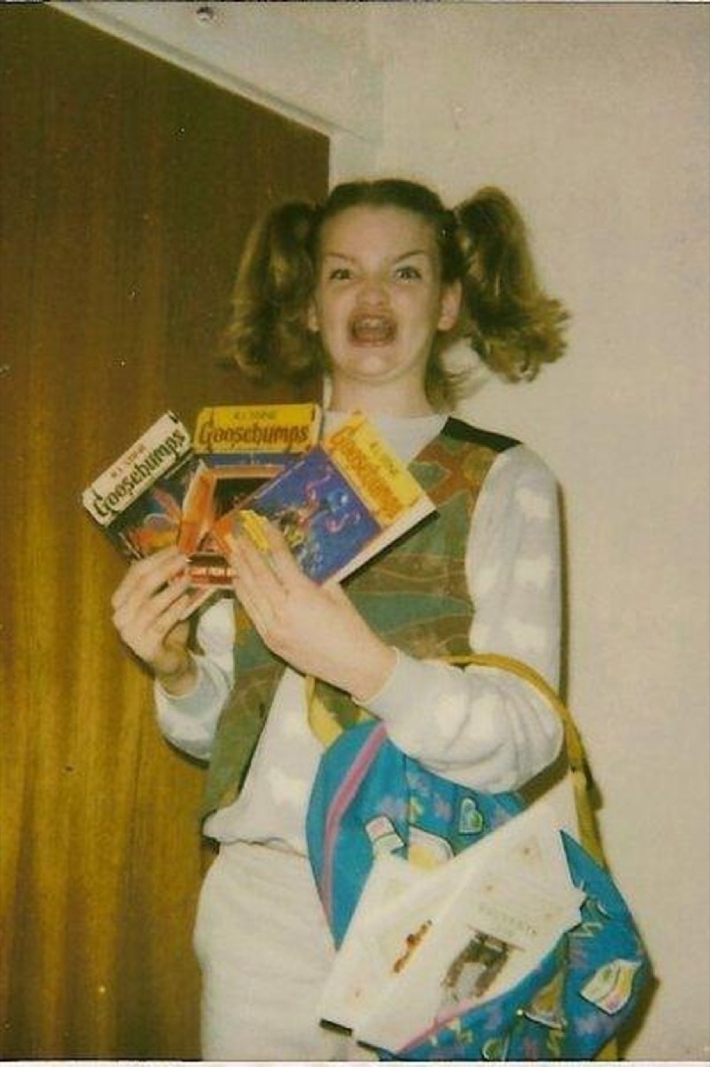 Girl in pigtails screaming wildly while clutching an armful of Goosebumps books