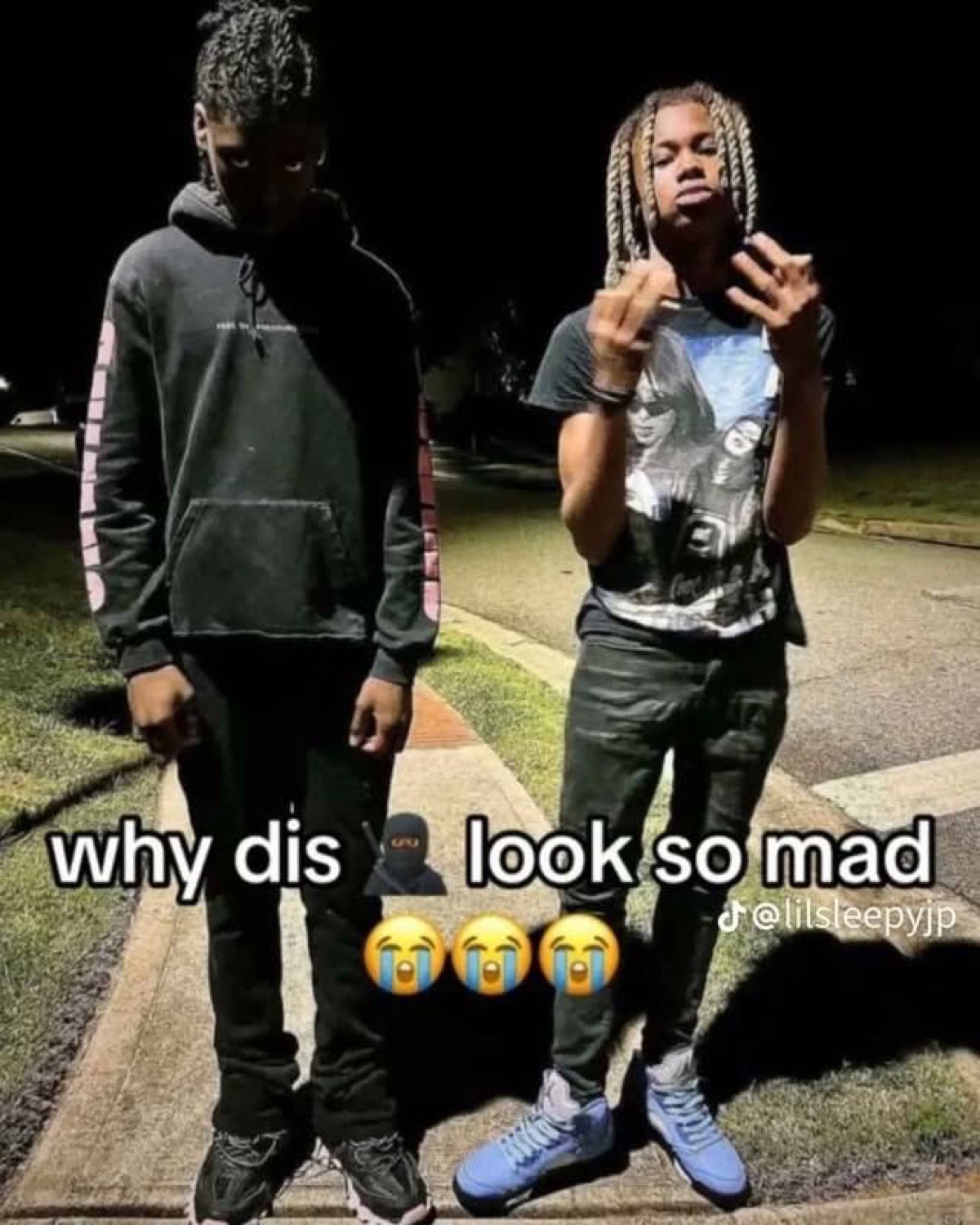 Two guys posing at night captioned 'why dis look so mad' over the sulking one