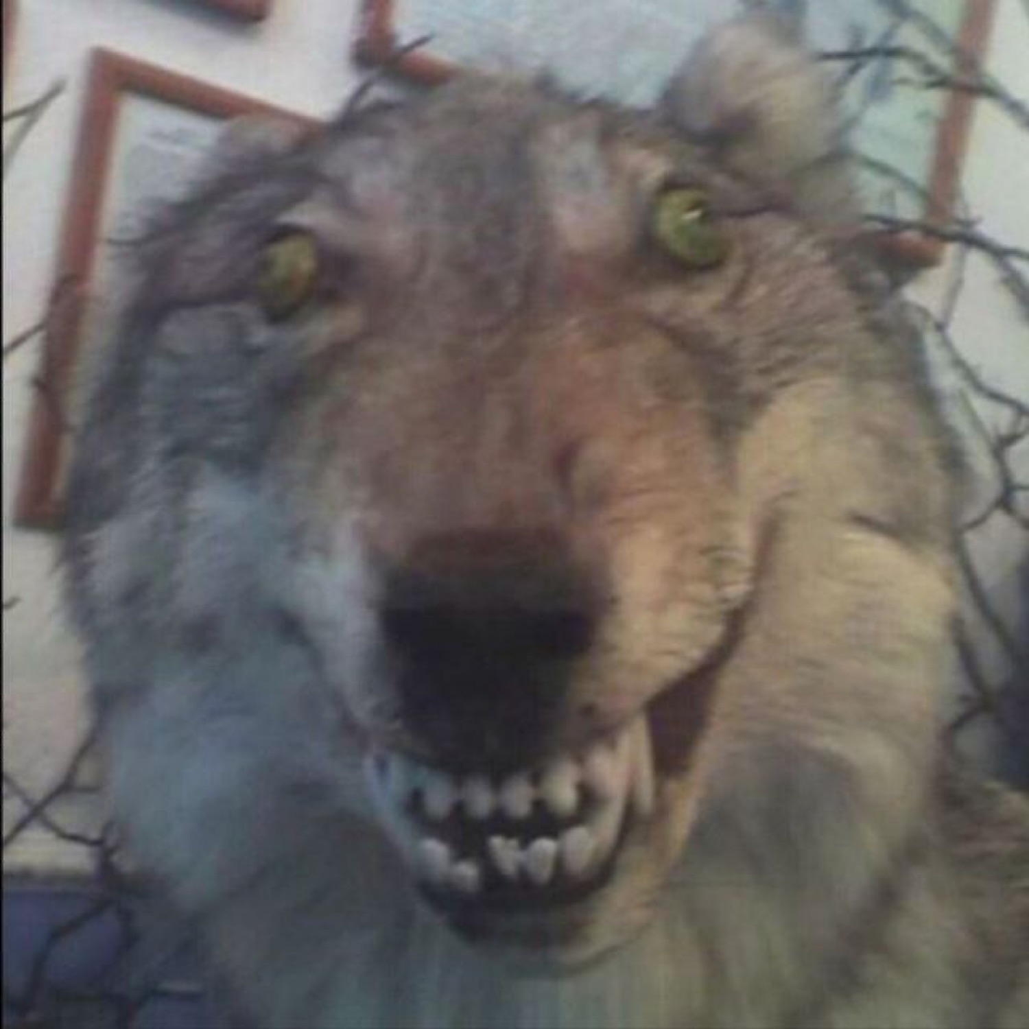 Snarling taxidermied wolf head with glowing green eyes and bared teeth staring you down