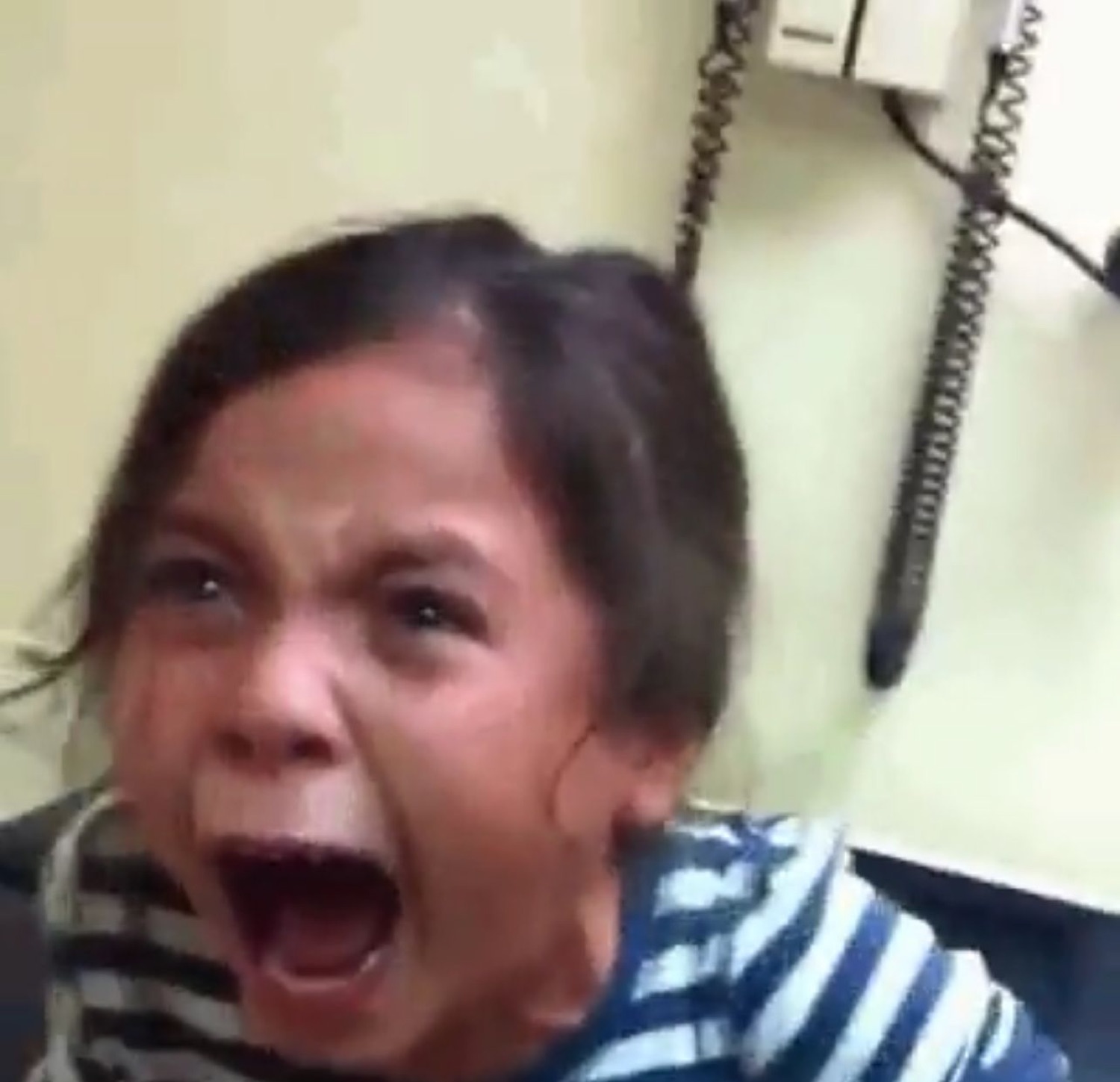 Little girl screaming furiously with her mouth wide open