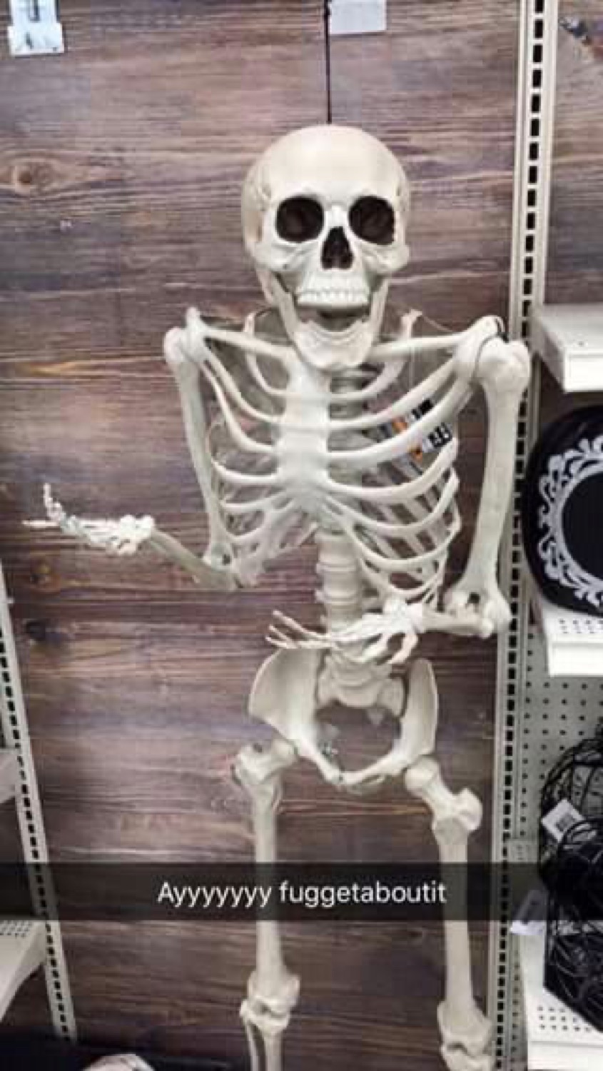 Store skeleton with an arm out on a Snapchat captioned 'Ayyyyyyy fuggetaboutit'
