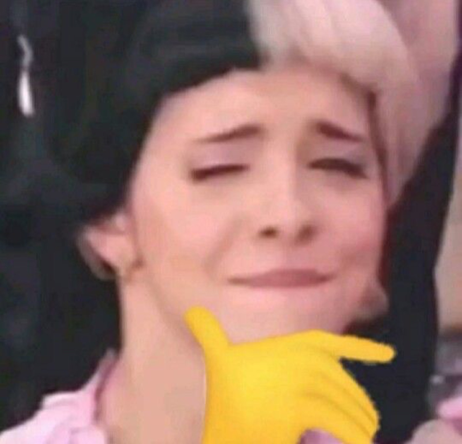 Melanie Martinez biting her lip with a chin-rub gesture
