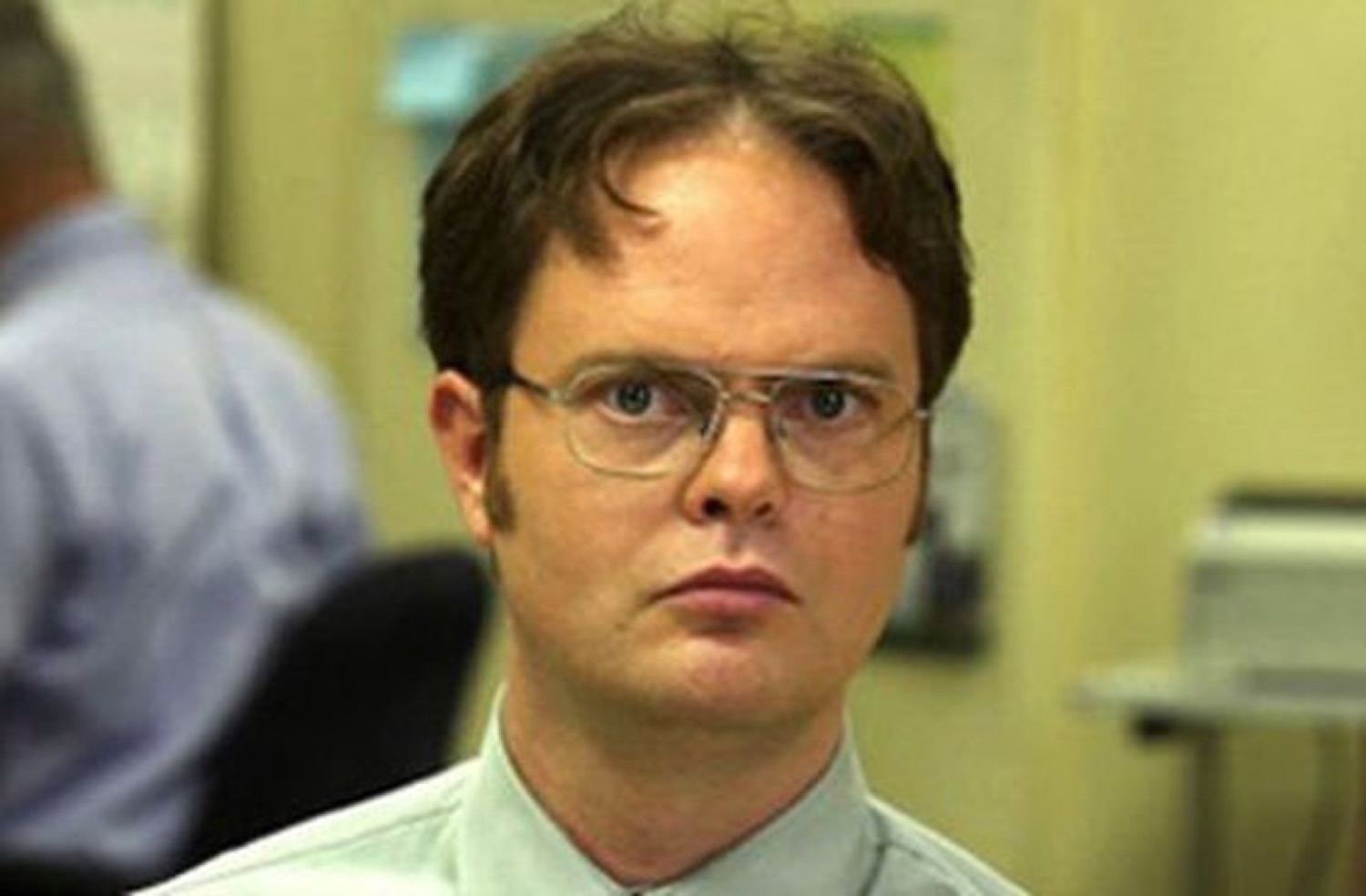 Dwight Schrute in his glasses giving a flat, deadpan, judgmental stare at the office