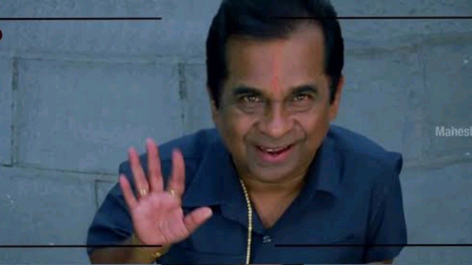 Brahmanandam holding up his hand with a grin