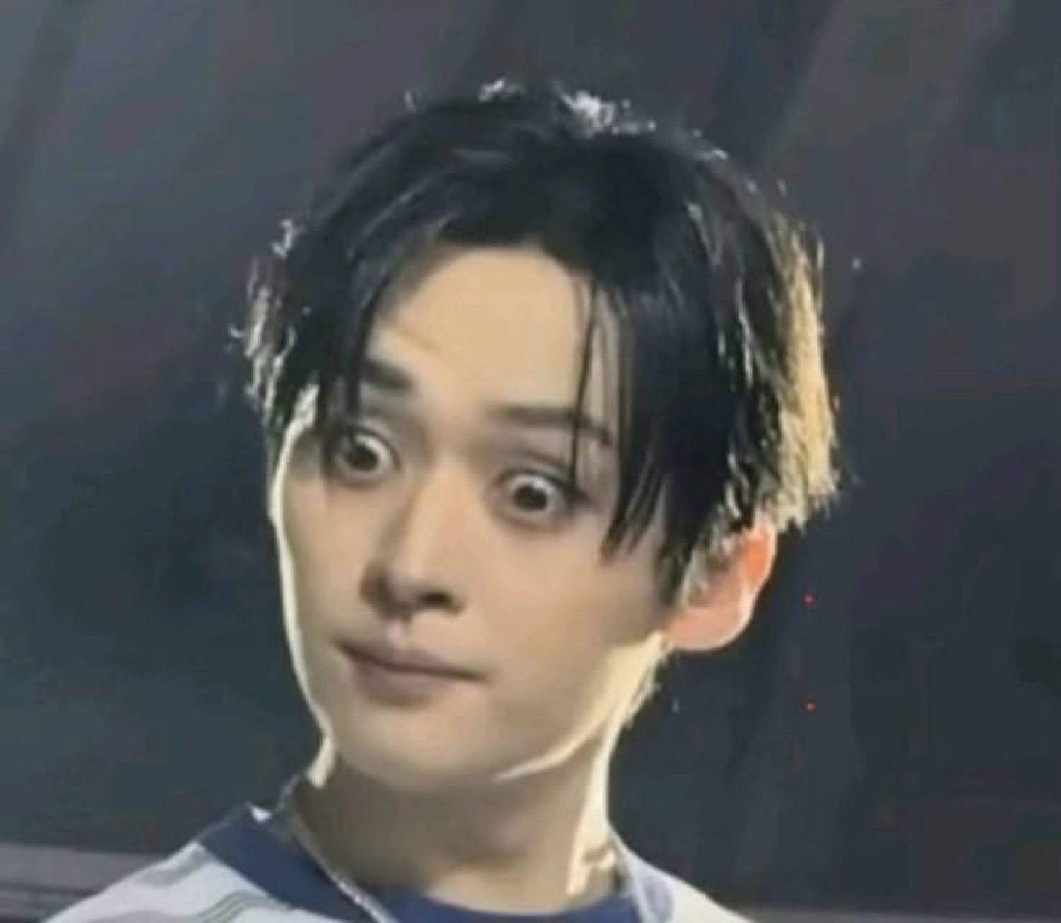 Young man with dark hair making a wide-eyed, awkwardly startled face