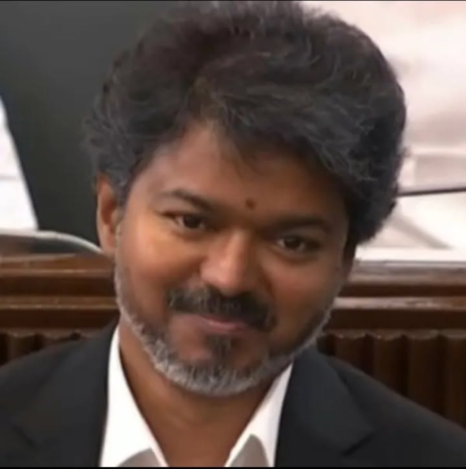 Bearded Vijay with a calm smile