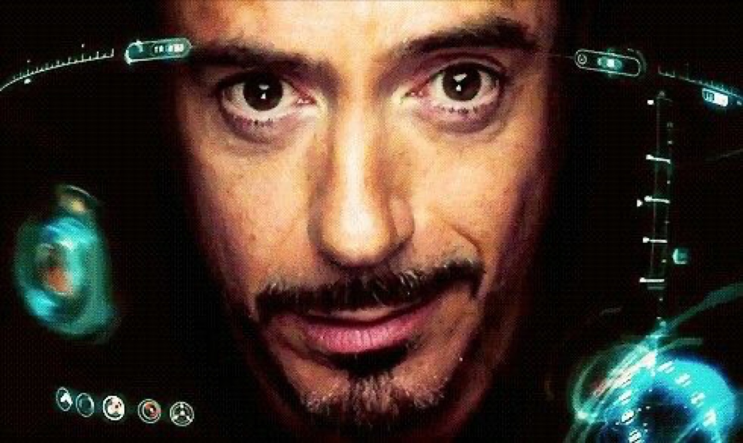 Tony Stark's face lit by holographic displays, staring intently ahead