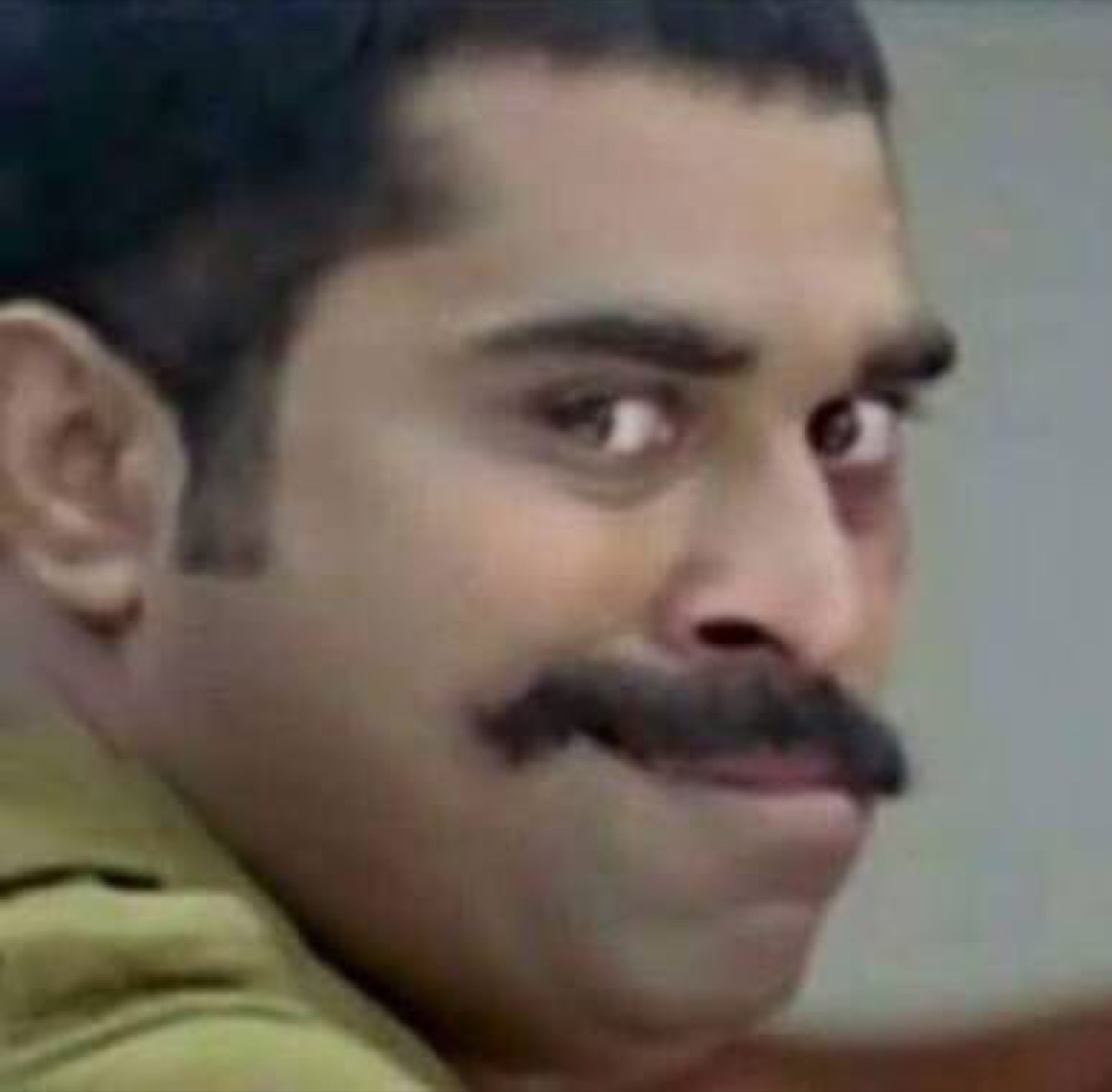 Suraj Venjaramoodu giving a sly sideways smirk