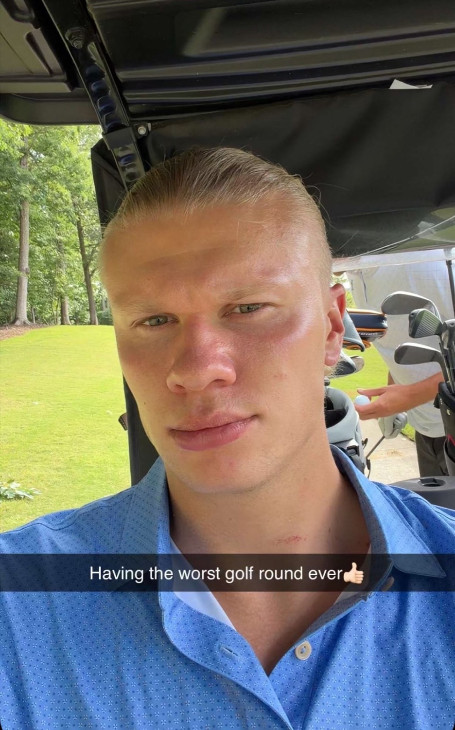 Erling Haaland with a completely blank face on a golf cart captioned 'Having the worst golf round ever'