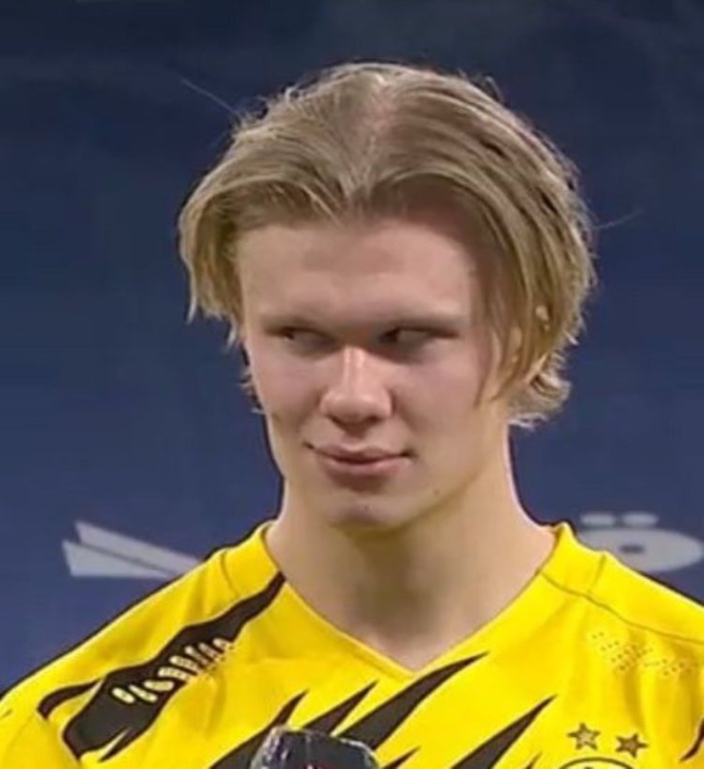 Erling Haaland in a yellow kit giving a smug little sideways smirk after a match