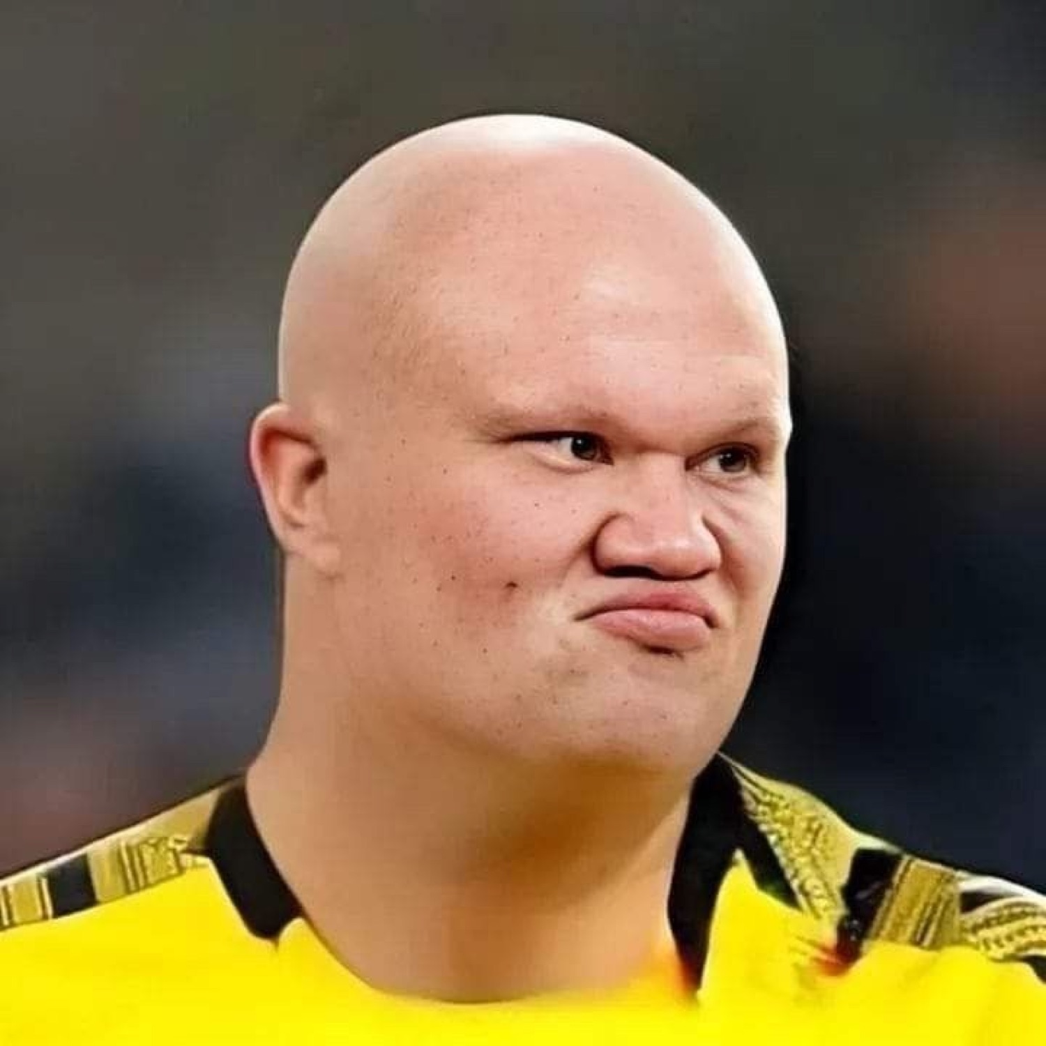 Bald man in a yellow jersey scrunching his face in unimpressed disgust