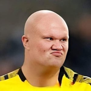 Bald man in a yellow jersey scrunching his face in unimpressed disgust