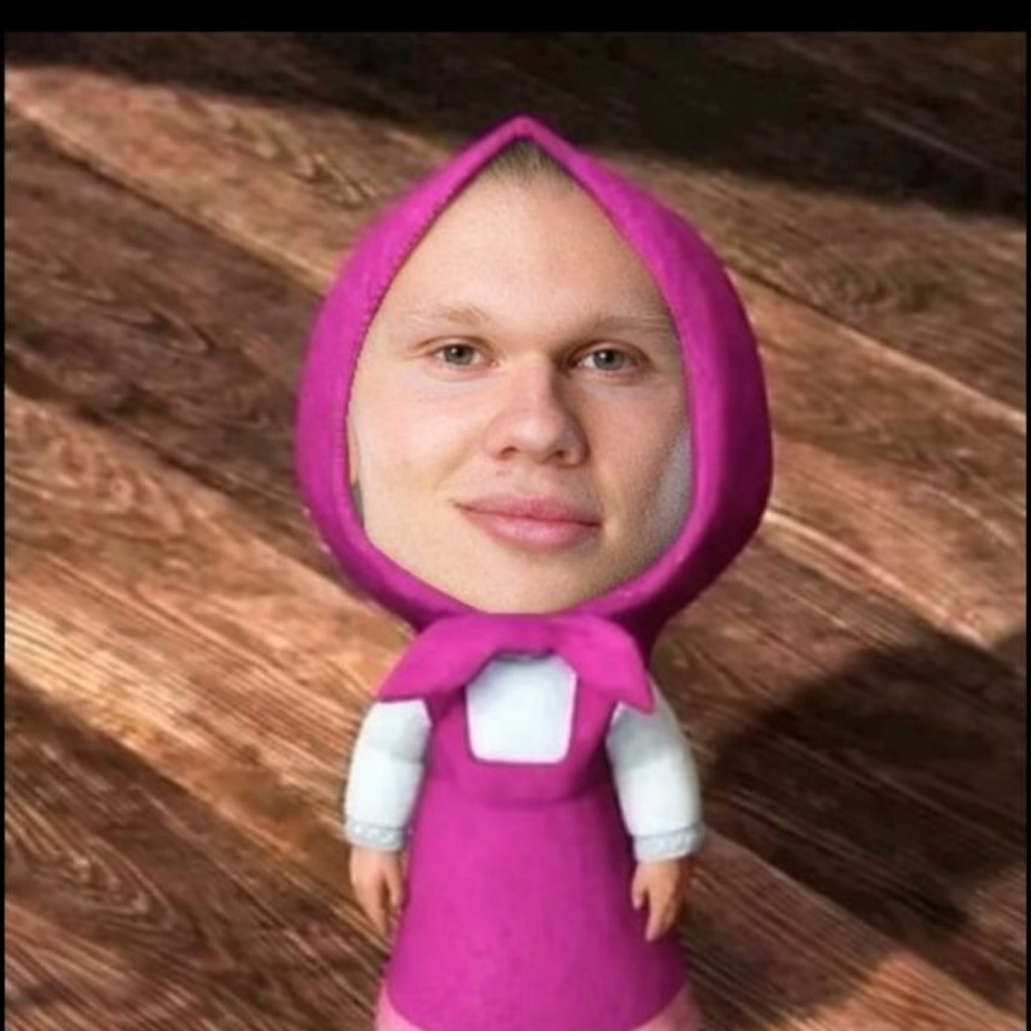 A man's deadpan face swapped onto the Masha cartoon doll in a pink outfit