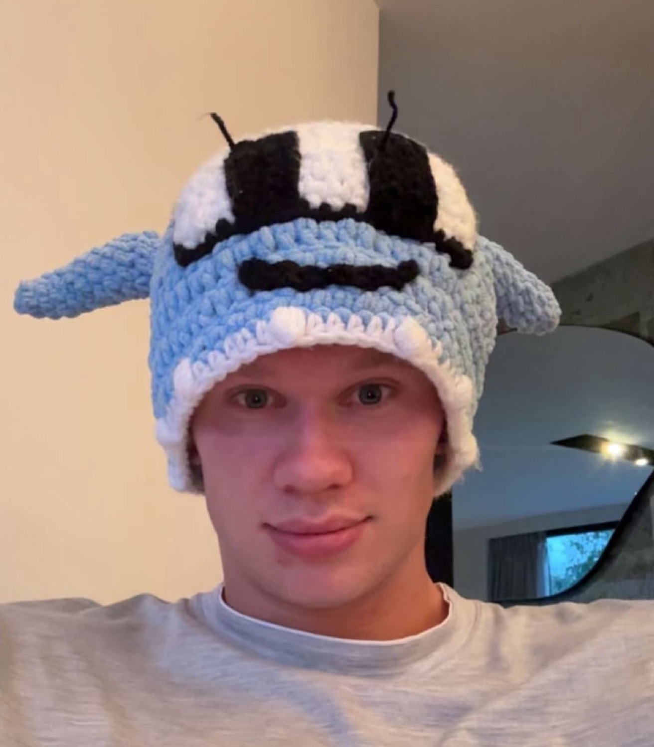 Blond guy in a knitted bee hat with a totally deadpan face
