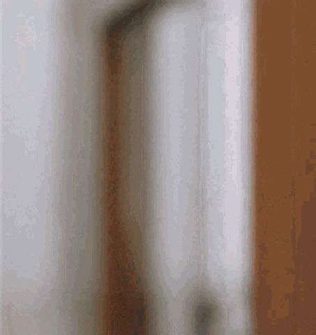 Man leaning out from behind a door nodding and giving a thumbs up