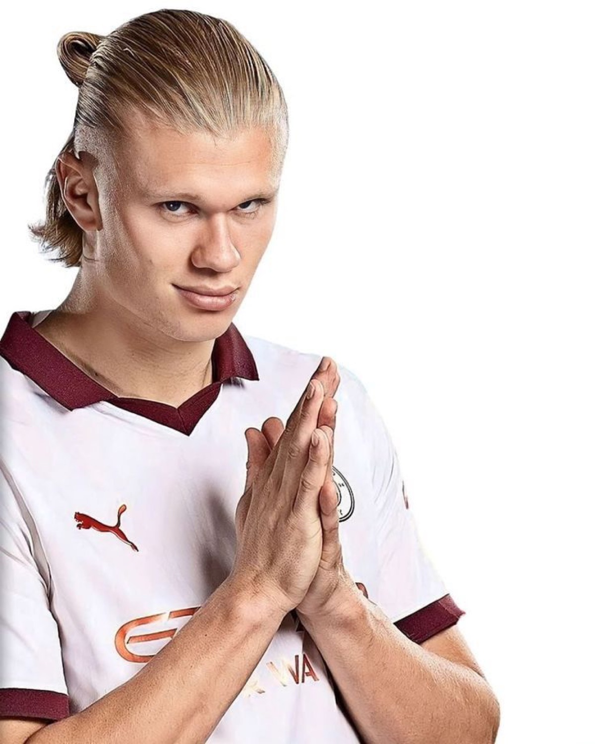 Erling Haaland in a white kit pressing his palms together with a smug little smirk