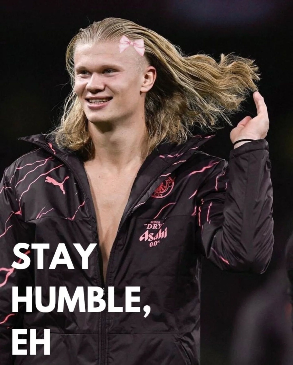 Erling Haaland flipping his long hair with a pink bow in it captioned 'STAY HUMBLE, EH'