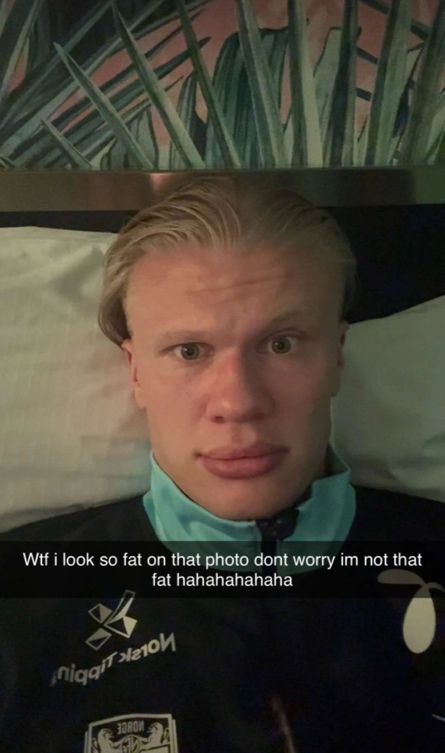 Blond footballer lying in bed with a deadpan selfie captioned 'im not that fat hahaha'