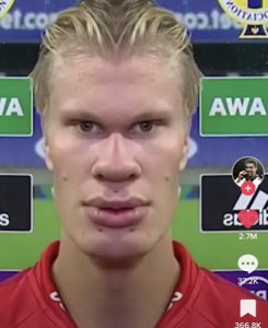 Erling Haaland staring into the camera with a completely blank, unreadable expression at a post-match interview