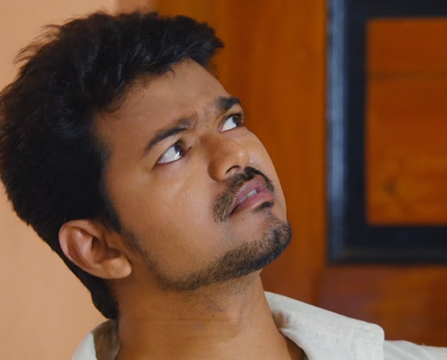 Vijay glancing up with a sideways eye-roll