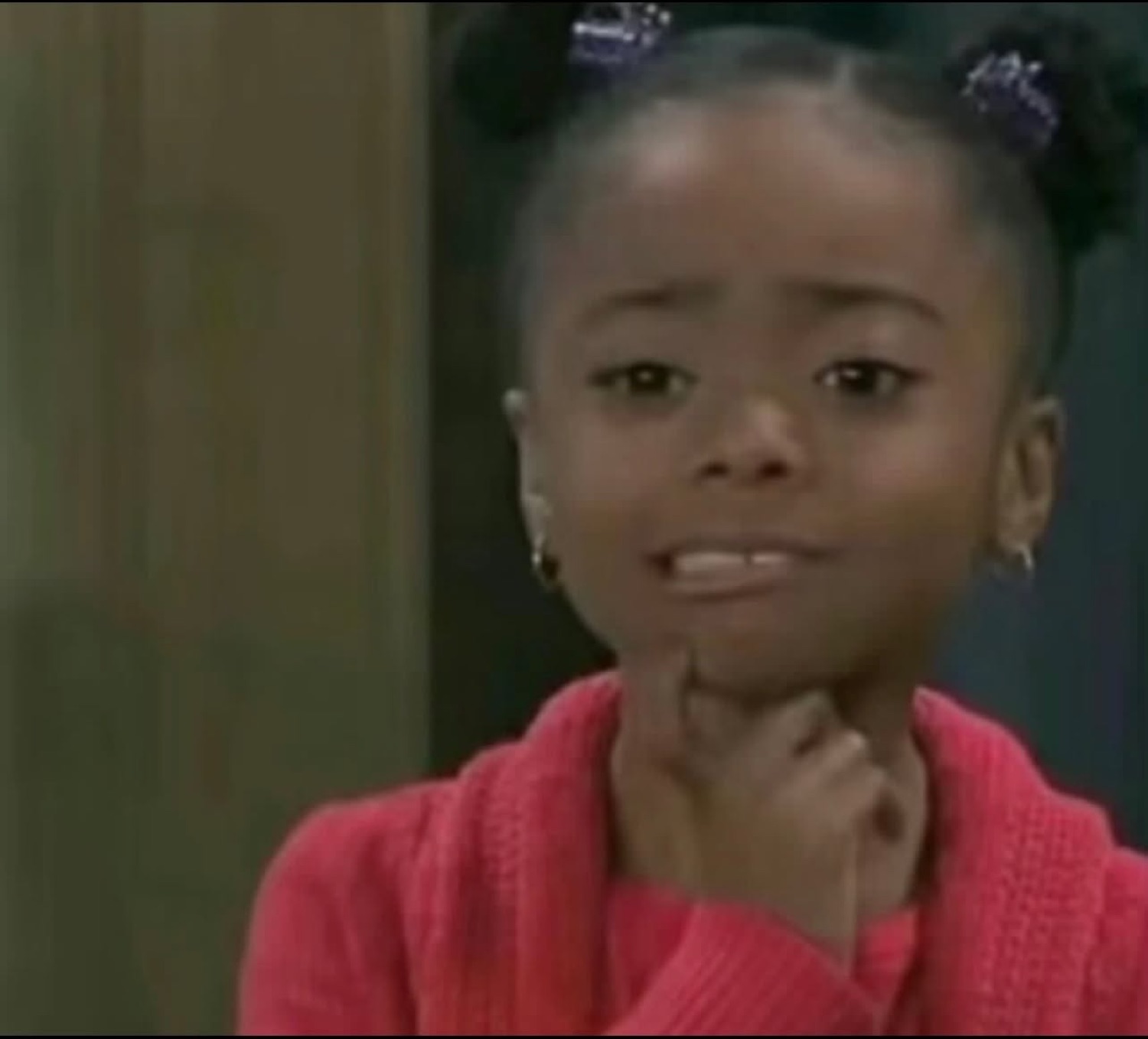 Skai Jackson with a hand on her chin and a skeptical look